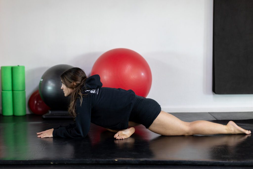 A woman is performing a stretch on mat